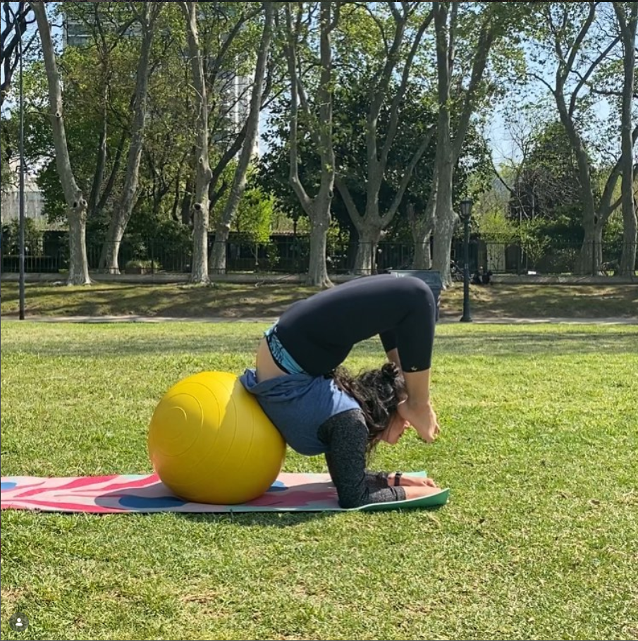 Ejercicio de extensión de espalda con pelota, en clase al aire libre